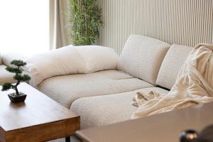 un sofá blanco en una sala de estar con mesa en Luxury 1-Bedroom Apartment with Hall in Mamsha, en Sharjah