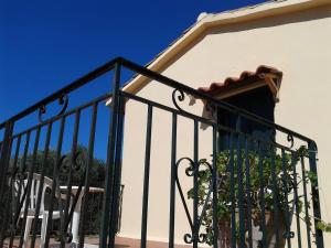 a balcony with a black railing with a plant at Ktima Tzamika in Episkopí- Rethimno