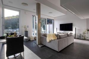 Una sala de estar con un sofá y un televisor. en Neu PENTHOUSE MoselTop Luxus Design Klima 2P, en Traben-Trarbach