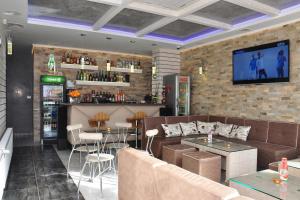 a restaurant with couches and a tv on a brick wall at Lombardi Family Hotel in Ruse