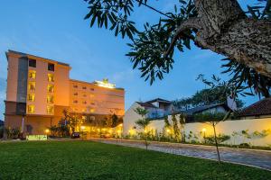 三寶壟的住宿－三堡壟港奴曼酒店，享有酒店夜间草坪的景色