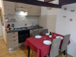 a kitchen with a table with a red table cloth at La dimora di Alice in Sassari