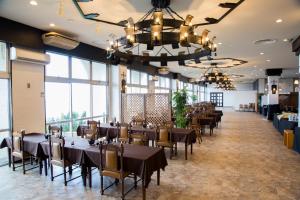 une salle à manger avec tables et chaises et de grandes fenêtres dans l'établissement Lido Park Resort Hachijo, à Hachijō 13 autres photos