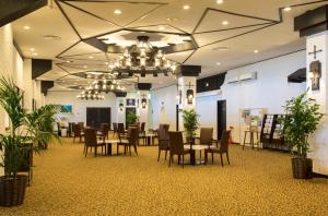 a dining room with tables and chairs and a chandelier at Lido Park Resort Hachijo in Hachijo