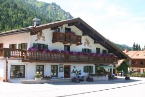ein Gebäude mit einem Balkon mit lila Blumen darauf in der Unterkunft Gästehaus Gritscher in Josefsthal