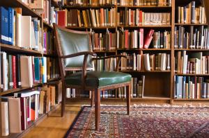 una silla sentada frente a un estante de libros en Haus Schlesien en Königswinter