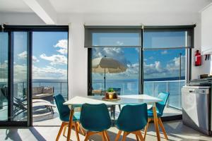 Una cocina y un comedor con mesa y sillas. en The Wave House - Two Bedroom Flat, en Jardim do Mar