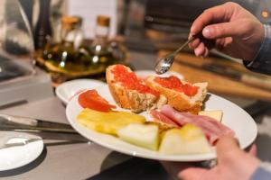 a person is eating food on a plate at Gar Anat Hotel Boutique in Granada