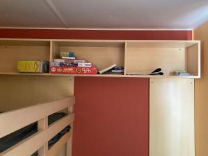 un armario con una pared roja y un estante en mobil home personnes, en La Tranche-sur-Mer