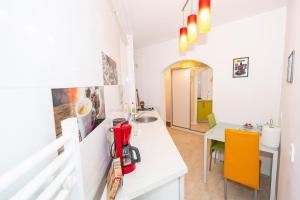 a kitchen with a counter and a sink and a table at Apartament Faleza in Galaţi