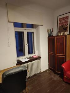 a living room with a chair and a window at Biały dom Cyprysowa 11 in Warsaw