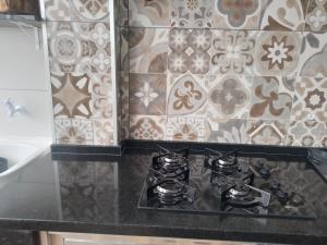 een fornuis in een keuken met tegels op de muur bij Cobertura com churrasqueira São Vicente in São Vicente +77 foto's