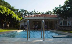 a swimming pool in front of a house at Oasis Beach House in Sonsonate