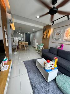 ein Wohnzimmer mit einem blauen Sofa und einem Tisch in der Unterkunft Gaia Residences, Gamuda Garden, 3 min to Skyline Luge in Rawang