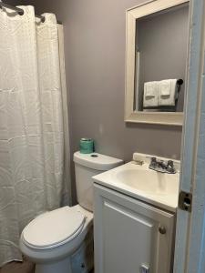 a bathroom with a toilet and a sink and a mirror at Live In Lodge Lilburn in Snellville