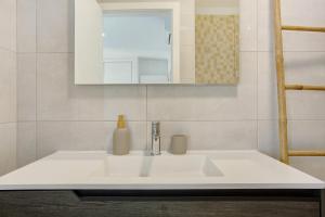 un bagno con un lavandino bianco e uno specchio di Casa Do Tempo com Jacuzzi a Ribeira Brava Altre 23 foto
