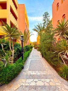 un sentiero in pietra tra due edifici con palme di Spacious 3BR Apartment - Al Dora Resort, Hurghada a Hurghada