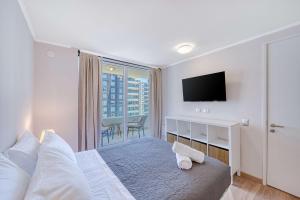 a bedroom with a bed with a television and a balcony at Vista Infinita in Concón