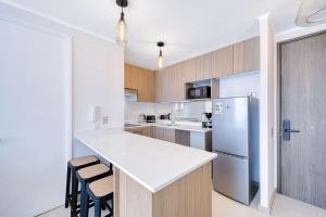 a kitchen with a white counter and a refrigerator at Vista Infinita in Concón