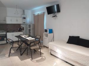 a room with a table and a bed and a kitchen at CABAÑAS DEL ANGEL in Capilla del Monte +13 photos