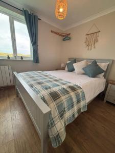 a bedroom with a bed with a plaid blanket at Dunes View - Atlantic Bay in Perranporth