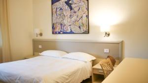 a hotel room with a bed and a painting on the wall at Rex Hotel Residence in Genoa