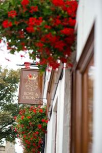 un cartello sul lato di un edificio con fiori rossi di The Rose & Crown York a York