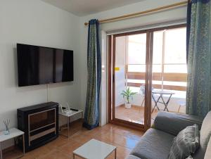 ein Wohnzimmer mit Couch und Flachbildfernseher in der Unterkunft Por el Placer de Vivir in Albir