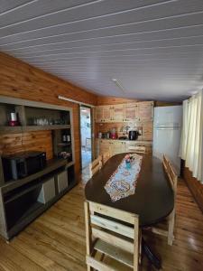 a kitchen with a table and some wooden cabinets at Casa Rústica Iguaçu in Foz do Iguaçu