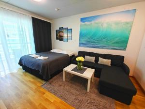 a living room with a bed and a couch at Top location IICenter IIParking in Oulu
