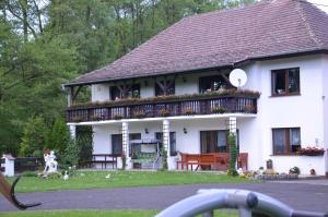 a white house with a balcony with flowers on it at Agroturystyka Nad Stawem in Centawa +21 photos