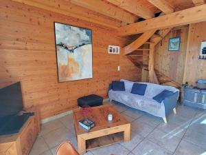 a living room with a couch and a tv at Chalet en bois 6 pers. avec terrasse Sud, lumineux et équipé, animaux admis – Saint-Michel-de-Chaillol - FR-1-393-12 in Saint-Michel-de-Chaillol