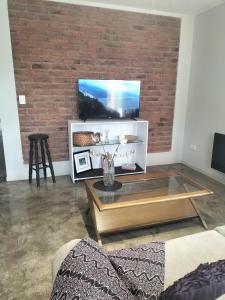a living room with a brick wall and a coffee table at Relax MDZ - Memorable Apt in Godoy Cruz