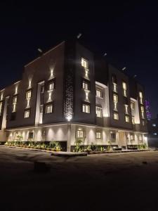 un grande edificio è illuminato di notte di استديو مودرن في الشمال بطابع فني والوان هادئة a Riyad