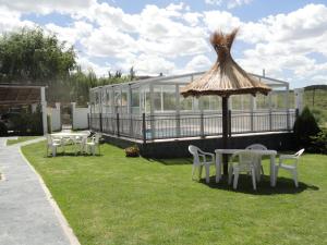 波特雷罗德洛斯弗内斯Pauvalén Cabañas的一座配有桌椅和遮阳伞的建筑 更多4张照片