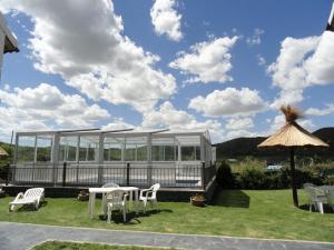 波特雷罗德洛斯弗内斯Pauvalén Cabañas的凉亭配有白色的椅子、桌子和遮阳伞