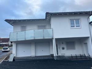 a white house with a balcony on the side of it at Ferienwohnung zum Gasthaus Hecker Hof in Bad Salzungen