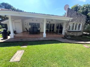 a house with a patio and a yard at Oasis Beach House in Sonsonate