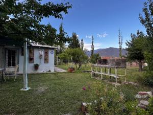 une maison avec un banc dans une cour dans l'établissement Fox Den, à Luján de Cuyo