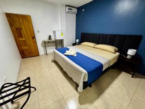 Un dormitorio con una cama grande con una pared azul. en Suite Arena, a pocos metros de la playa, en Puerto Baquerizo Moreno