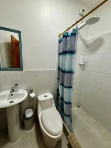 un baño con inodoro y lavabo en Suite Arena, a pocos metros de la playa, en Puerto Baquerizo Moreno