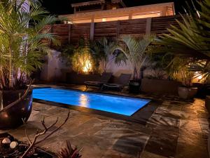 a swimming pool in a backyard at night at Villa passion vanille in Les Trois-Îlets