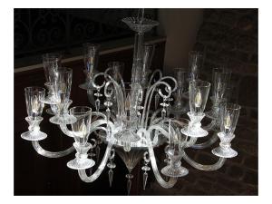 un lampadario pieno di bicchieri di vetro su un tavolo di La Meffrais 1741 - Manoir Élégant - B&B - Parking - 3 min de Dinan a Dinan