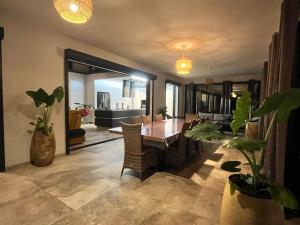 a dining room with a table and some plants at Villa passion vanille in Les Trois-Îlets