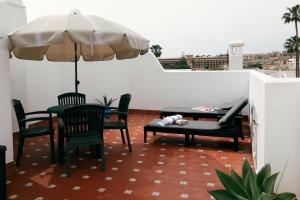 a patio with a table and chairs and an umbrella at Apartment in the center of La Cala de Mijas with Sea Views in Mijas