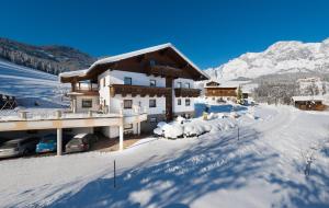 a house with a herd of sheep in the snow at Apartments Haus Huber in Mühlbach am Hochkönig