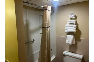 a bathroom with a shower and a toilet and towels at Fairview Inn By OYO Hesston I-135 in Hesston