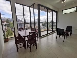 a dining room with a table and chairs and windows at Quatre bornes APARTMENT NEW rooms COLIVING in Quatre Bornes