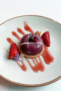 a dessert on a plate with strawberries and sauce at Aloft London Excel in London