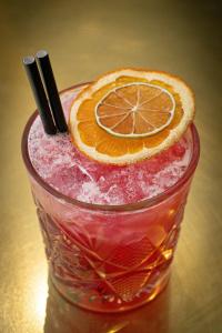 a drink with an orange slice on a table at Aloft London Excel in London